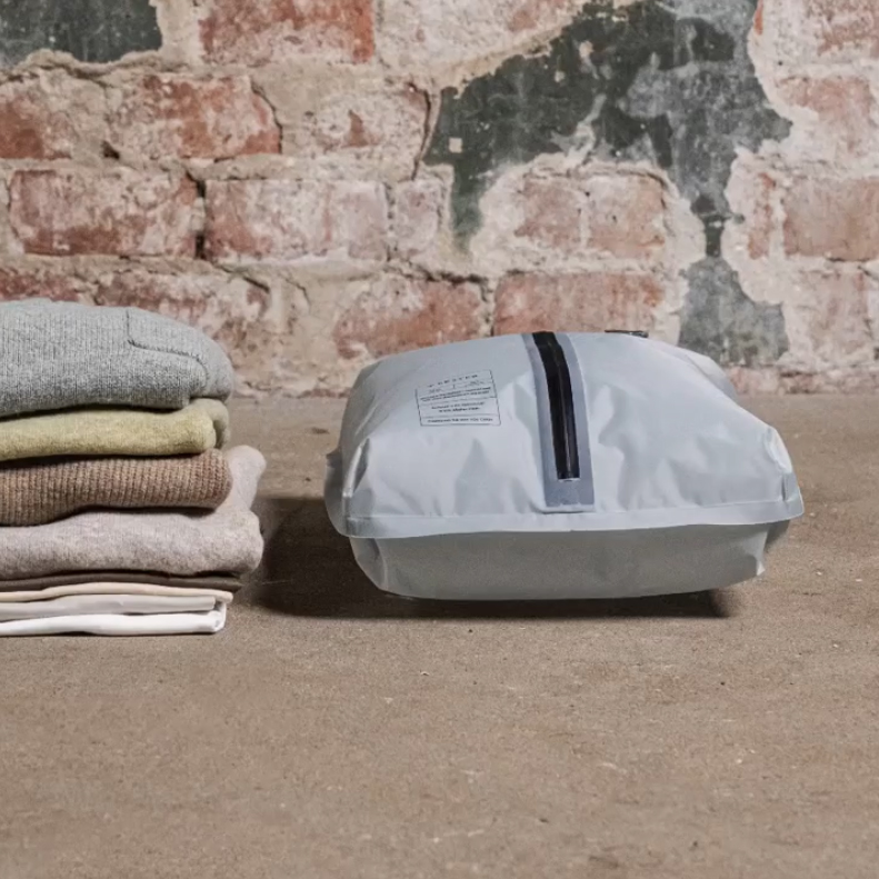 Reusable vacuum travel bag compressing clothing for space-saving packing and separating laundry while traveling