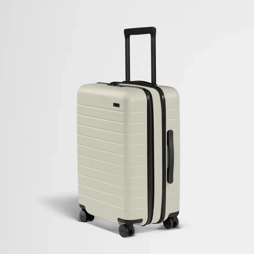 Hard-shell carry-on suitcase with spinner wheels and expandable zipper, ideal for minimalist travel and carry-on packing