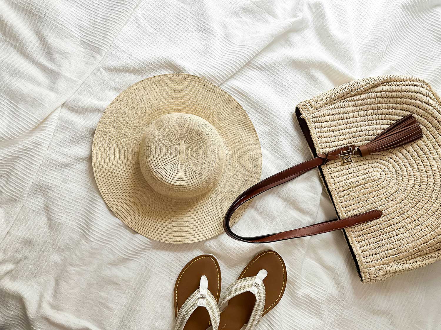 Carry-on travel essentials including water bottle, headphones, scarf, tote bag, and travel accessories